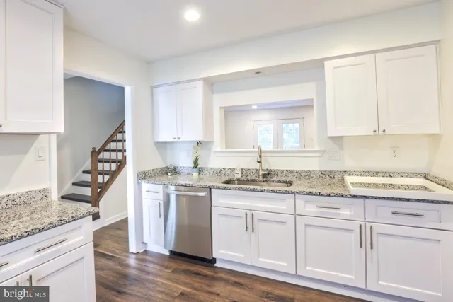 a kitchen with granite countertop a sink and cabinets