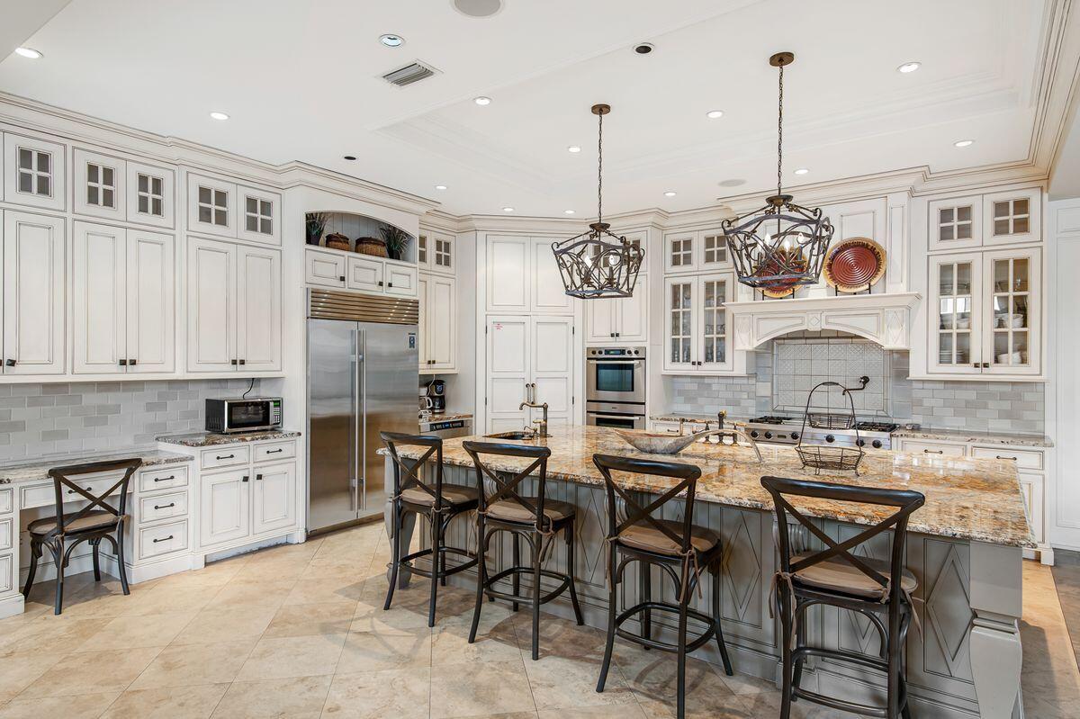 4789 Ocean Boulevard Destin, FL 32541 - Photo 4 of 47 a kitchen with stainless steel appliances kitchen island granite countertop a table chairs and a chandelier