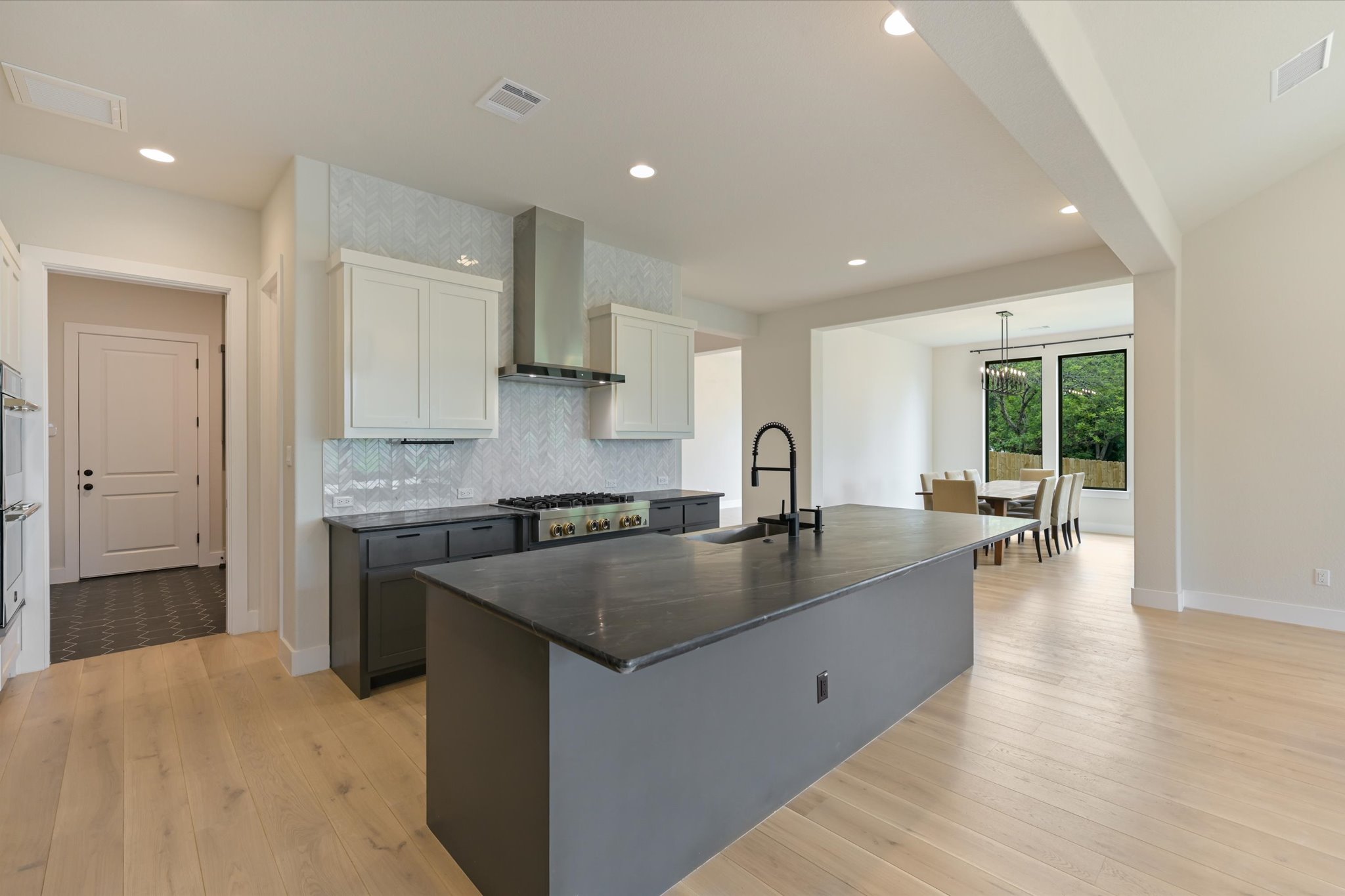 913 Presa Arriba Road Austin, TX 78733 - Photo 7 of 30 A contemporary kitchen features a spacious island with sink, perfect for culinary endeavors and casual dining.