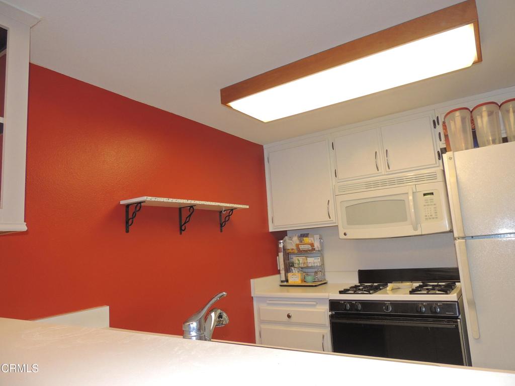 865 South B Street, Unit L2 Oxnard, CA 93030 - Photo 3 of 32 a kitchen with a sink a stove top oven and cabinets