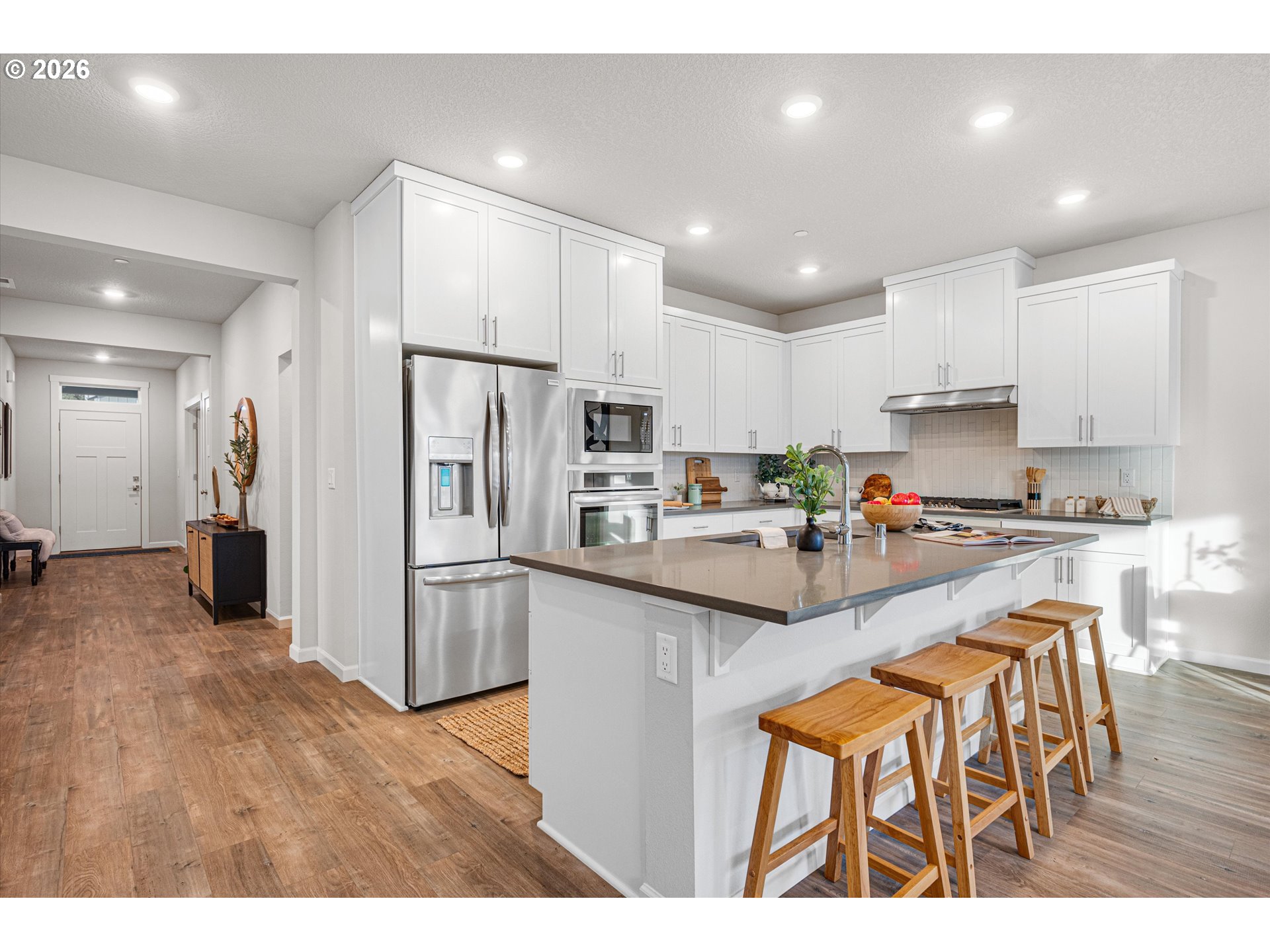 2637 South 6th Way Ridgefield, WA 98642 - Photo 12 of 41 a kitchen with stainless steel appliances granite countertop a refrigerator a sink dishwasher a stove and white cabinets with wooden floor