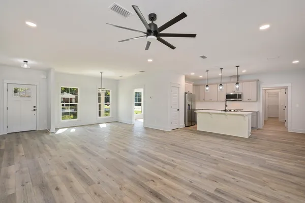 a view of an empty room with a kitchen