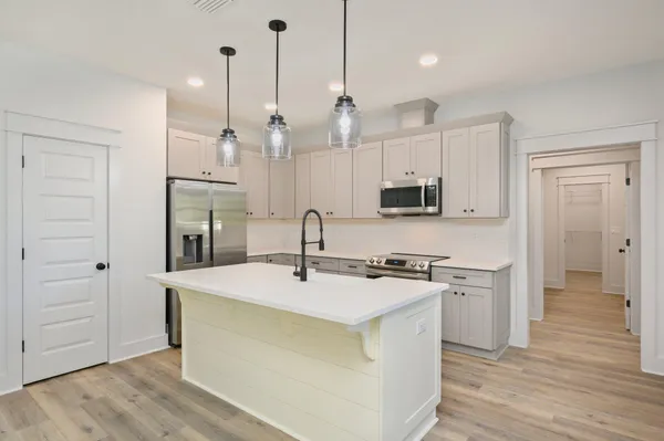 a kitchen with stainless steel appliances granite countertop a sink a stove and a refrigerator