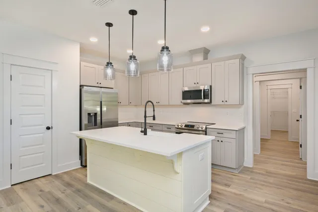 a kitchen with stainless steel appliances granite countertop a sink a stove and a refrigerator