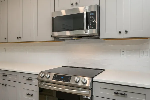 a stove top oven sitting inside of a kitchen