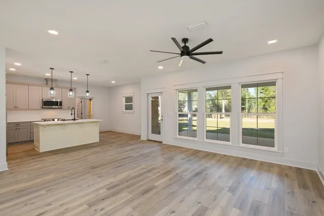 a large kitchen with stainless steel appliances kitchen island a large counter top and a wooden floors