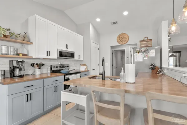 a kitchen with kitchen island a counter top space stainless steel appliances and cabinets