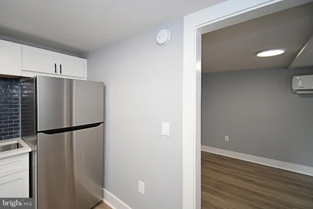 a view of a kitchen with a refrigerator and wooden floor
