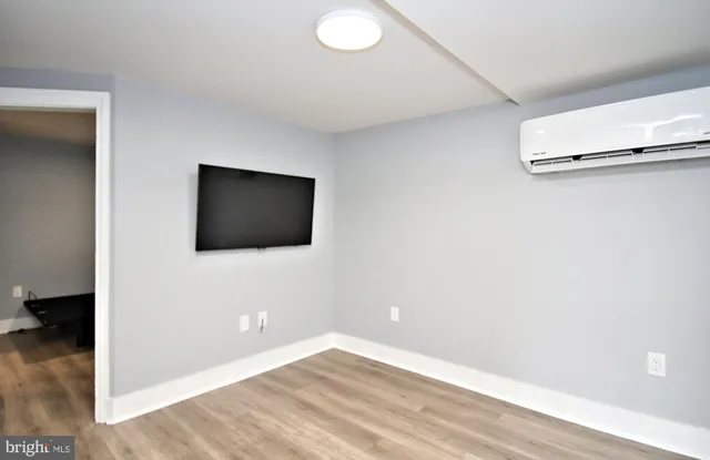 a view of a livingroom with wooden floor and a flat screen tv