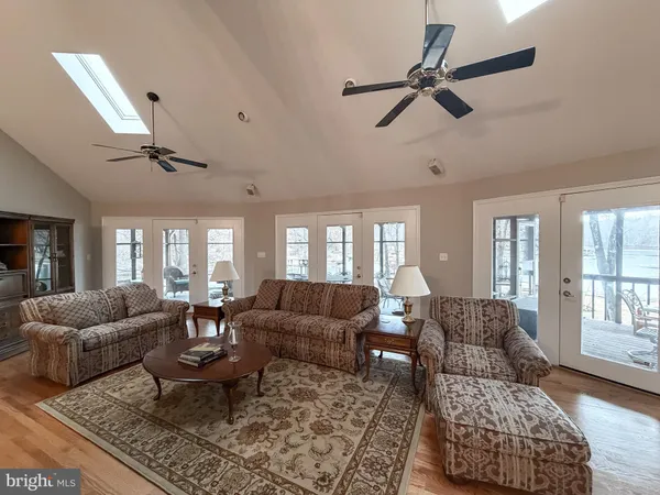 a living room with furniture kitchen view and a large window