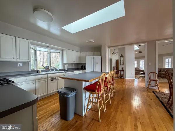 a kitchen with stainless steel appliances granite countertop a table chairs sink and cabinets