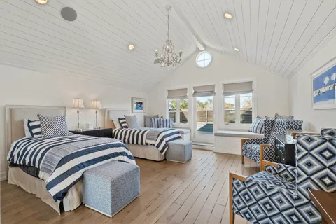 a spacious bedroom with two beds and a large window