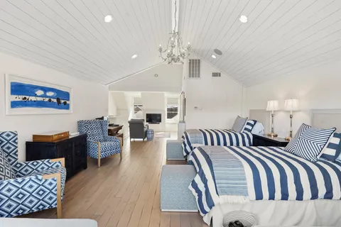 a spacious bedroom with a bed a couch and dresser