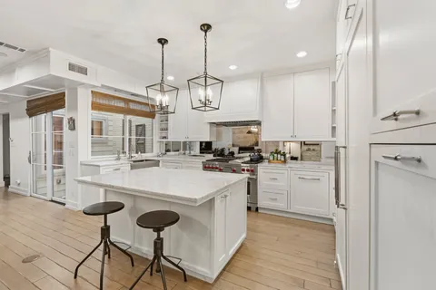 a kitchen with cabinets a center island and stainless steel appliances