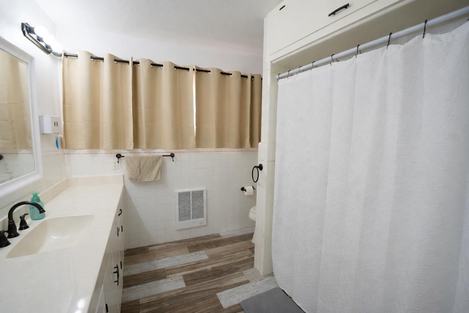730 South 17th Street Slaton, TX 79364 - Photo 13 of 23 a bathroom with a shower curtain and a sink