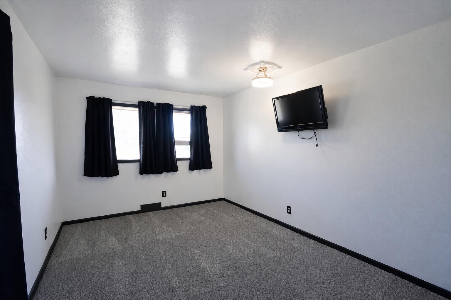 730 South 17th Street Slaton, TX 79364 - Photo 15 of 23 an empty room with windows flat screen tv and windows
