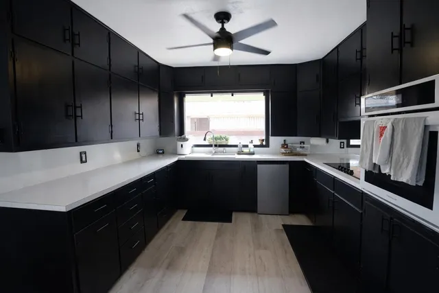 a kitchen with a sink a window and stainless steel appliances