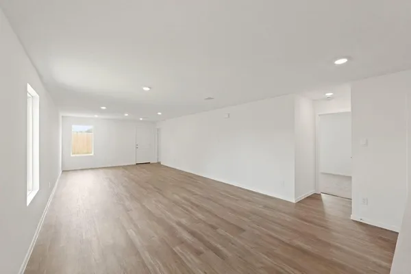 a view of an empty room with wooden floor