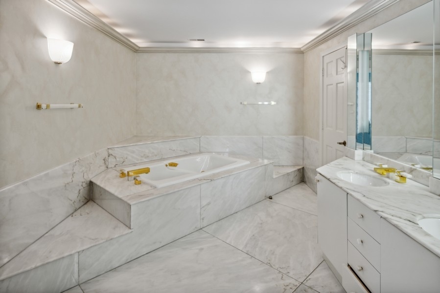 473 Sheridan Road Winnetka, IL 60093 - Photo 20 of 32 a bathroom with a tub sink and mirror