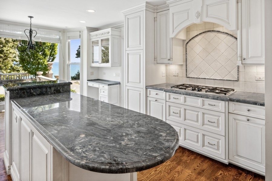 473 Sheridan Road Winnetka, IL 60093 - Photo 10 of 32 a kitchen with stainless steel appliances granite countertop a stove a sink and a microwave