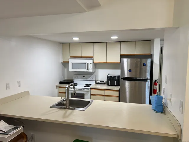 a kitchen with a refrigerator a stove and white cabinets