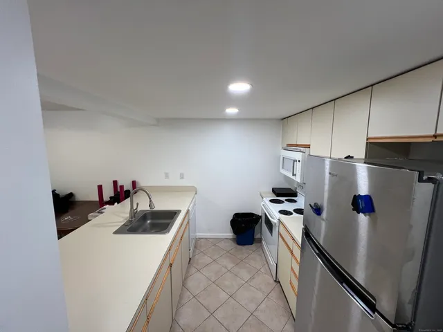 a kitchen with refrigerator and white cabinets