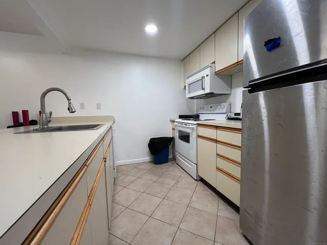a kitchen that has a sink a stove and a refrigerator