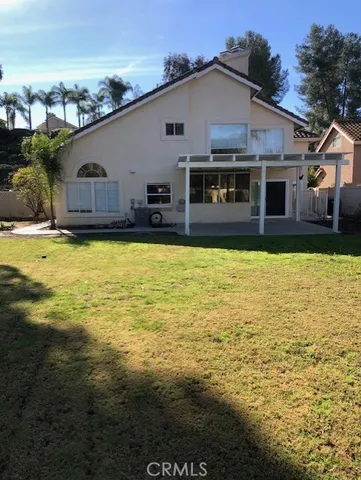 a front view of house with yard and lake view in back