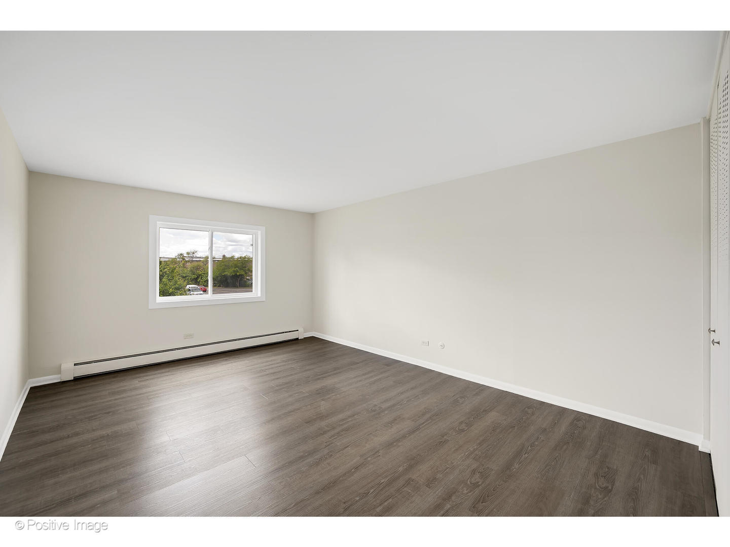 10377 Dearlove Road, Unit 5205 Glenview, IL 60025 - Photo 14 of 23 a view of an empty room with wooden floor and a window
