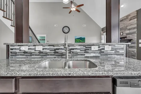 a kitchen with granite countertop a sink and a stove
