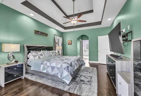 a bedroom with a bed and a flat screen tv