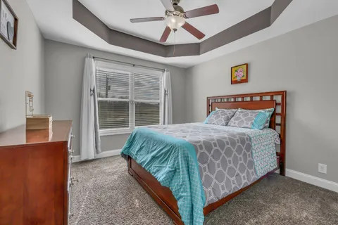 a bedroom with a bed and a ceiling fan