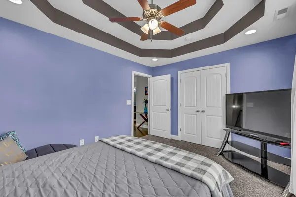 a spacious bedroom with a bed and a ceiling fan
