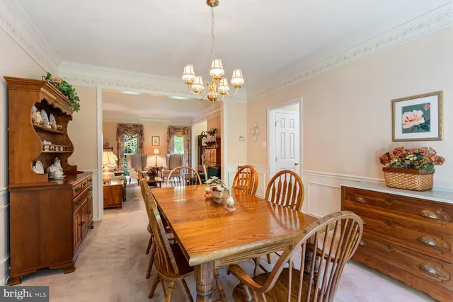 a dining room with furniture a chandelier and window
