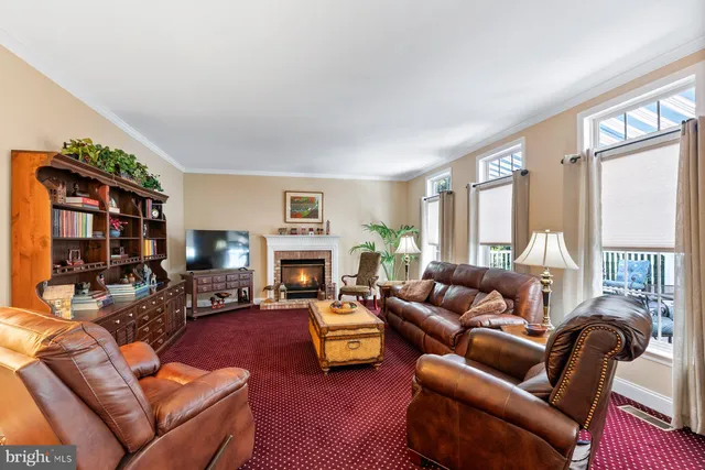 a living room with furniture fireplace and a large window