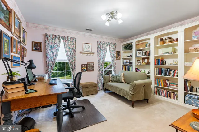a view of a livingroom with workspace and a window