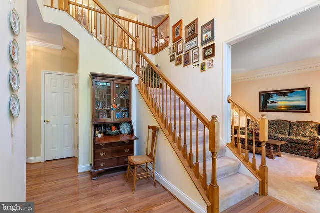 a view of staircase with lots of frames on wall and wooden floor