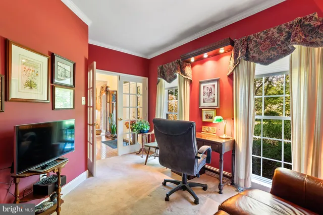 a view of a livingroom with workspace and a window