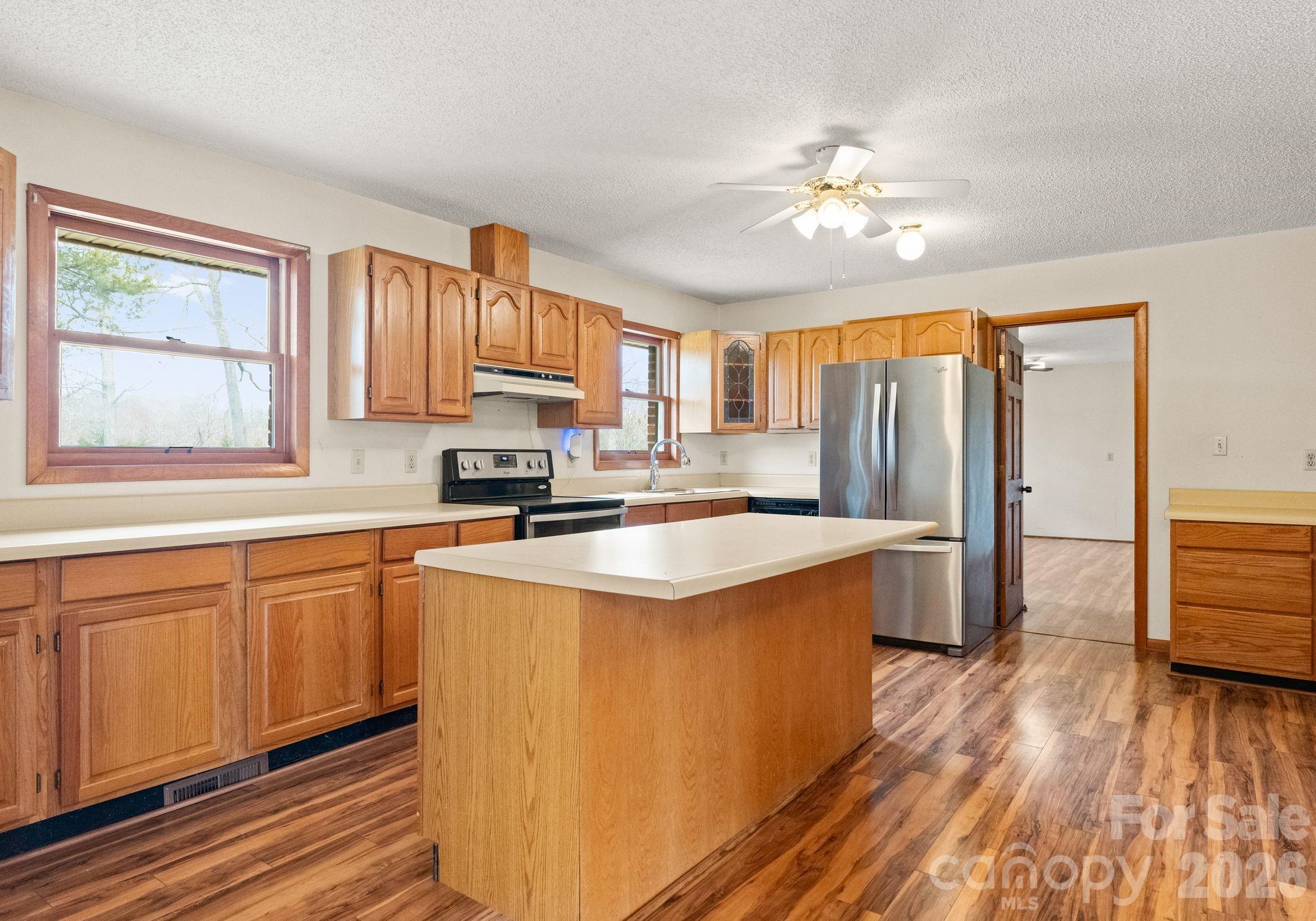 150 Barber Lyerly Road Salisbury, NC 28147 - Photo 8 of 43 a kitchen with stainless steel appliances granite countertop a refrigerator a sink dishwasher a stove with wooden cabinets and floor