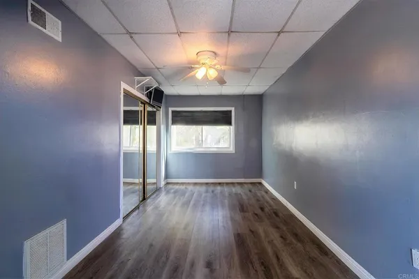 an empty room with wooden floor and windows