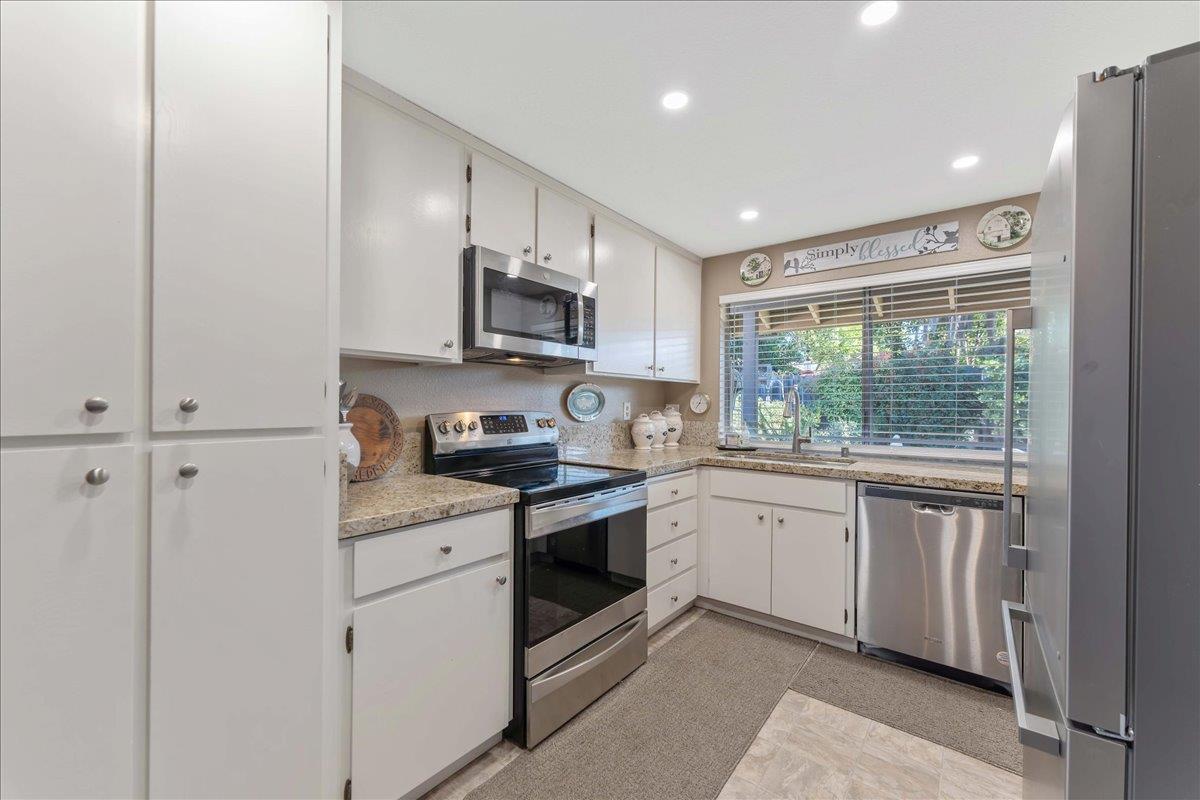 7770 Laurel Drive Gilroy, CA 95020 - Photo 11 of 35 a kitchen with stainless steel appliances granite countertop a stove a sink and a microwave