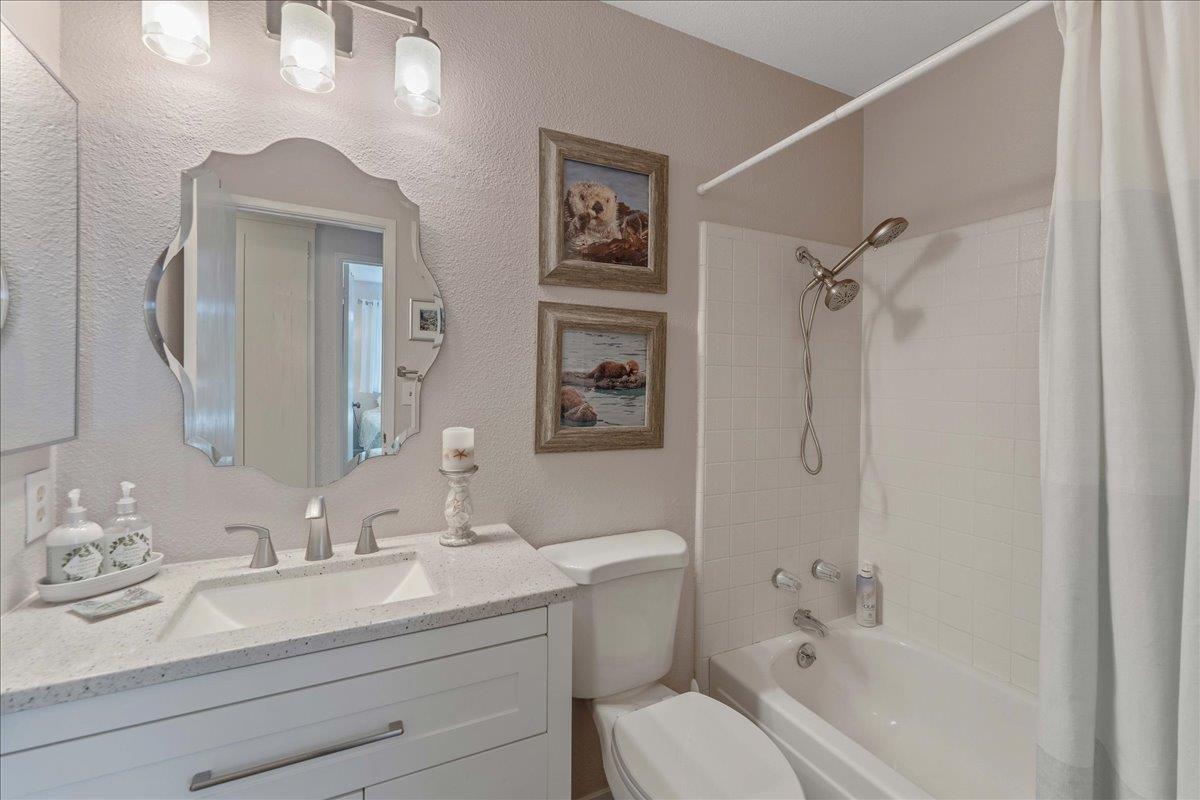 7770 Laurel Drive Gilroy, CA 95020 - Photo 26 of 35 a bathroom with a granite countertop sink toilet a mirror a vanity and shower
