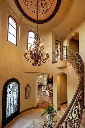 a view of a hallway with wooden floor and a chandelier