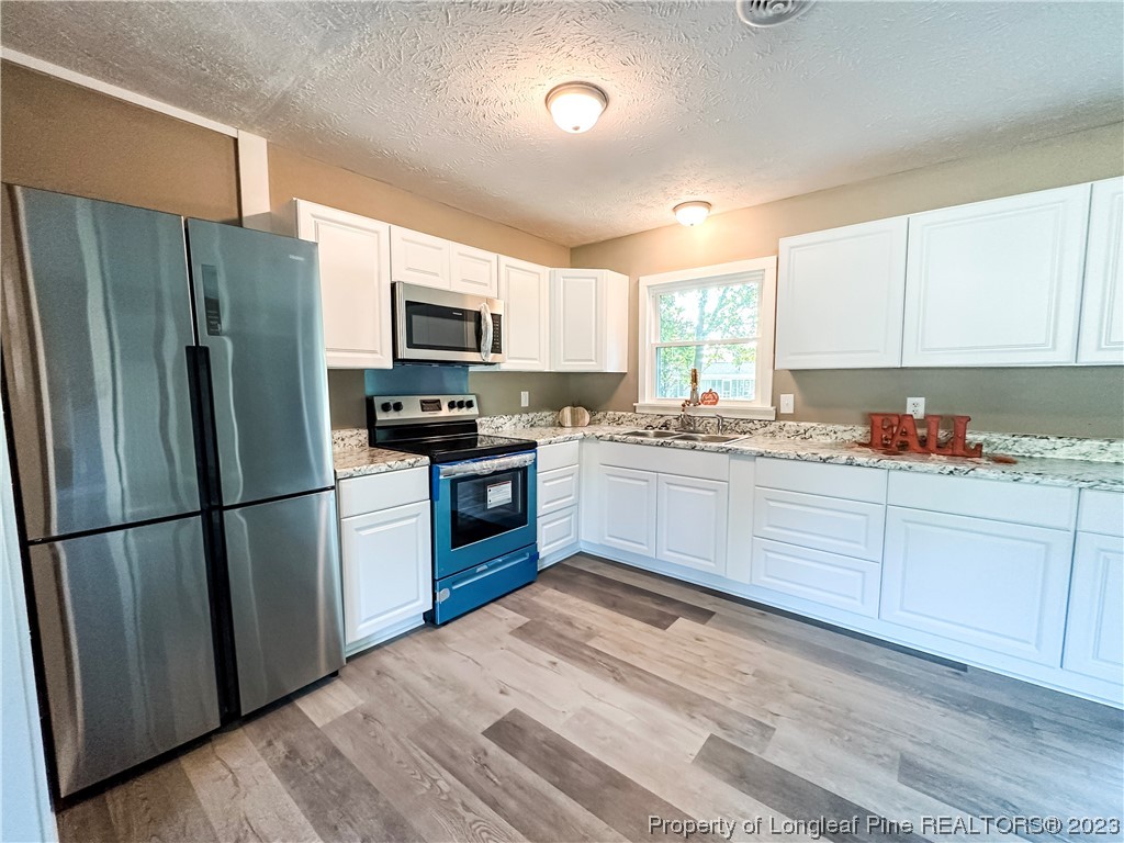 1645 Flintshire Road Fayetteville, NC 28304 - Photo 5 of 22 a kitchen with granite countertop stainless steel appliances a refrigerator sink and microwave