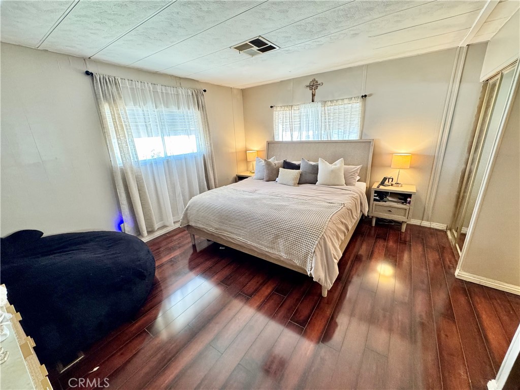 23301 Ridge Rte Drive, Unit 109 Laguna Hills, CA 92653 - Photo 23 of 46 a bedroom with a bed and wooden floor