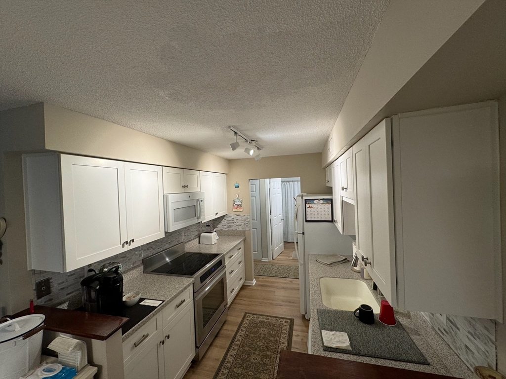 3 Beal's Cove Road, Unit H Hingham, MA 02043 - Photo 6 of 13 a kitchen with a sink and refrigerator