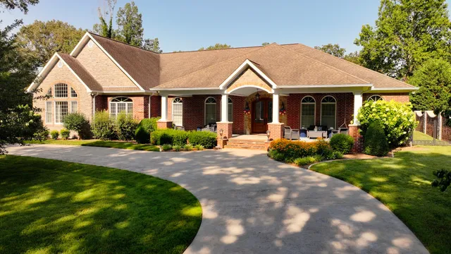 a view of a white house with a big yard and potted plants