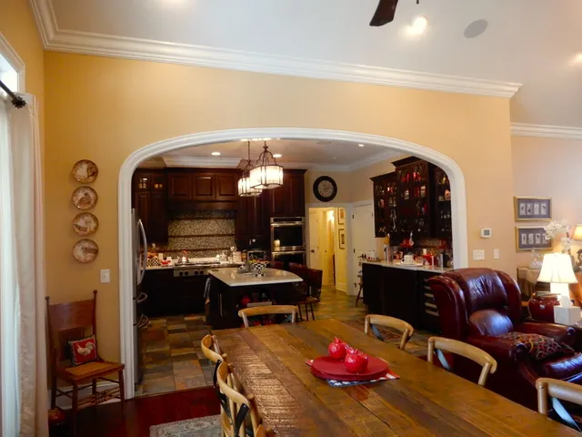 a view of a brick house with a small yard and a large tree