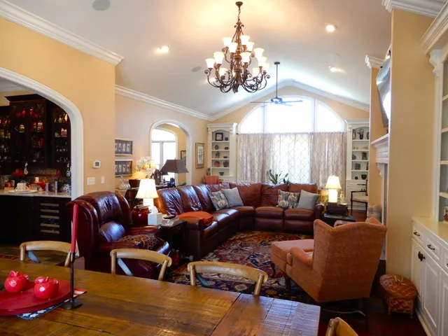 a living room with furniture a chandelier and a flat screen tv