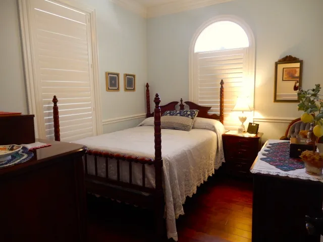 a view of a white house next to a yard